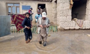 A Concern staff member walks through flood waters in Afghanistan