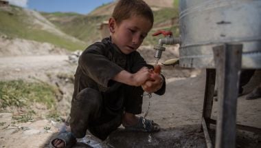 Child uses handwashing station in Afghanistan