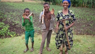 Female Ethiopian farmer with her sons in her field