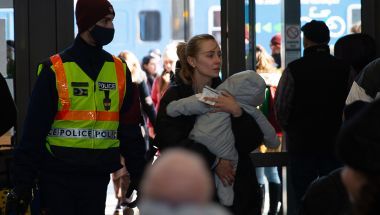 Woman carrying child into train station