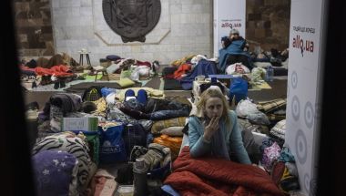 Woman looking worried amid sleeping bags in train station