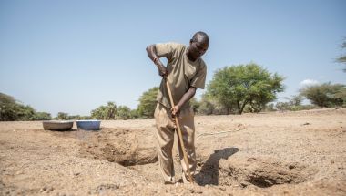 Joseph fetches water from a hand-dug well that his community is currently relying on in Northern Kenya