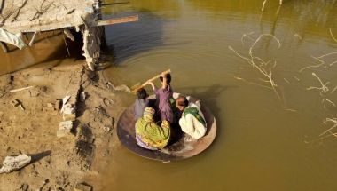 Aqib Aliin (14) transports people on his frying pan across the flooded waters in Jhuddo town of District Mirpurkhas of Sindh, Pakistan, in October 2022. The worst floods in decades impacted over 33 million people. Photo: Emmanuel Guddo/Concern Worldwide