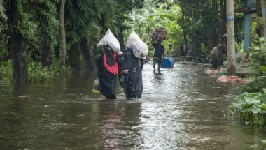 Women walk through flooded streets