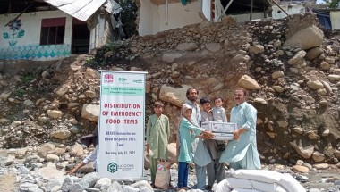 Family receiving dry food ration packs in Pakistan
