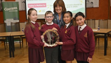 Students in red uniforms stand in Stormont holding awards