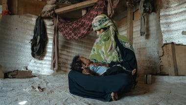 A mother cradles her young son in a displacement camp in Yemen
