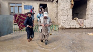 A Concern staff member walks through flood waters in Afghanistan