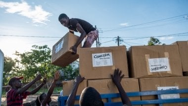 Esparanza Maria, a 25-year-old day worker from Nhamatanda, helps load boxes containing essential household supplies from a warehouse to a truck. The items will be distributed the next day in the village of Ndeja. &quot;It makes me feel good to be able to help 