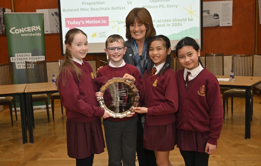 Students in red uniforms stand in Stormont holding awards