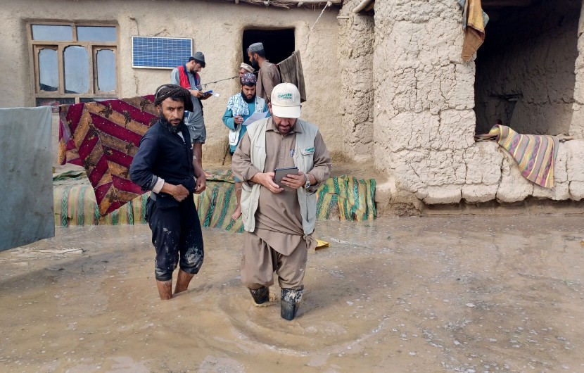 A Concern staff member walks through flood waters in Afghanistan