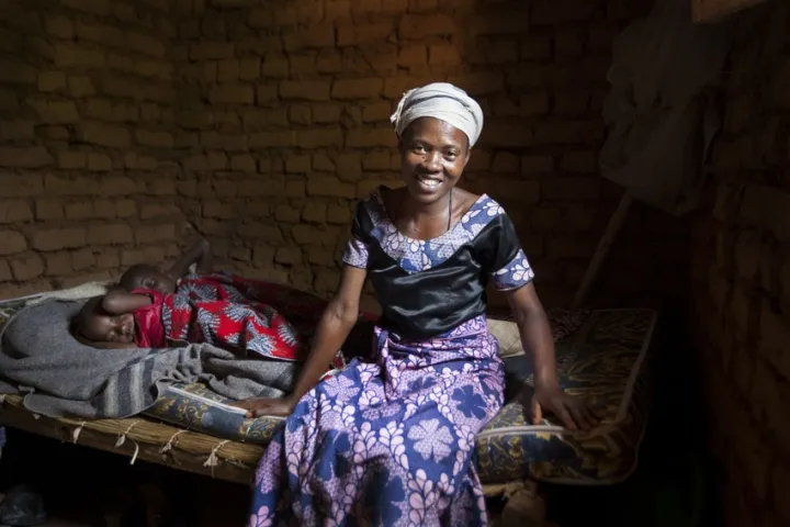 Jeanne D’Arc Niyingabiye (31) is a beneficiary of the Graduation Programme, photographed here on her new mattress bought by profits of her business with her 2 youngest children Marie-Noella Arakaza 7 (F) and Queen-Pacis Bukeyeneza 4 (F) at their home in Mabayi, Cibitoke, Burundi. All 3 of her children attend school. Photo: Abbie Trayler-Smith / Concern Worldwide Jeanne D’Arc Niyingabiye (31) is a beneficiary of the Graduation Programme, photographed here on her new mattress bought by profits of her business with her 2 youngest children Marie-Noella Arakaza 7 (F) and Queen-Pacis Bukeyeneza 4 (F) at their home in Mabayi, Cibitoke, Burundi. All 3 of her children attend school. Photo: Abbie Trayler-Smith / Concern Worldwide