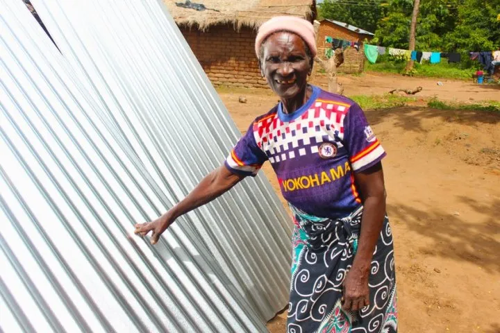 Dorcia, 71, with her brand-new waterproof roof sheets. Photo: Jason Kennedy / Concern Worldwide Dorcia, 71, with her brand-new waterproof roof sheets. Photo: Jason Kennedy / Concern Worldwide