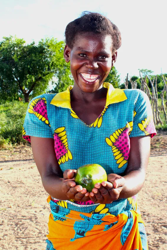 Malita shows off one of the avocados she’s grown in Malawi, with the support of Concern. Photo: Jason Kennedy / Concern Worldwide