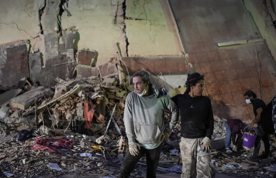 People stand at the site of a collapsed building following an earthquake in Caracas on June 25, 2026