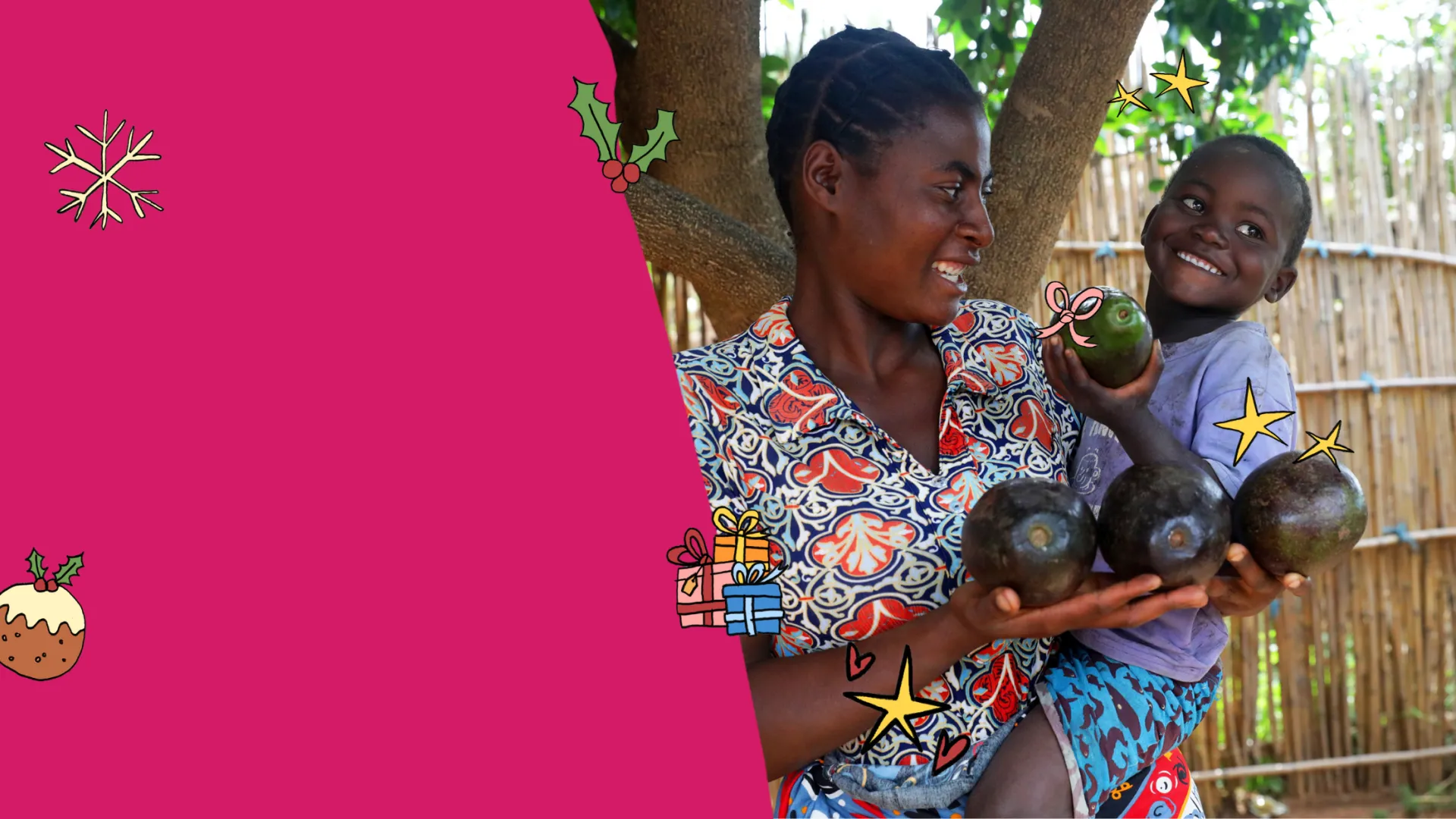 A smiling woman holds several avocados in her hands while carrying a young child, who happily holds up another avocado. They stand under a tree beside a wooden fence.