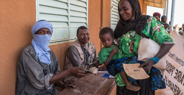 Gaichatou Mohamed receives a distribution of cash and fortified flour from Concern to help meet her basic needs during the hunger gap. The fortified flour is for her daughter Hadizatou and it contains vital nutrients and vitamins to help keep her well-nourished. Photo: Apsatou Bagaya / Concern Worldwide.