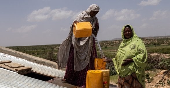 Women collect water from an underground tank. Photo: Eamon Timmins/Concern Worldwide