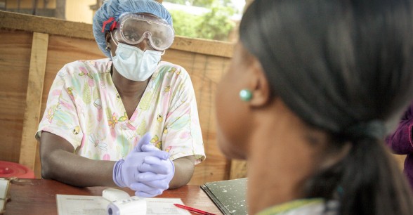 Nurse Emma Senesie at a screening area at Waterloo PHU in the east of Freetown checks all patients and visitors for signs of Ebola before they enter during Ebola outbreak in Sierra Leone.