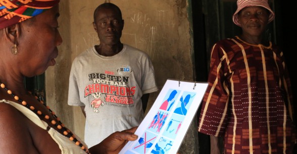 A resident of Bassaia Village Tonkolili District Northern Sierra Leone looks at a COVID-19 poster distributed by Concern Worldwide after a sensitization session. Photo: Mohamed Saidu Bah / Concern Worldwide