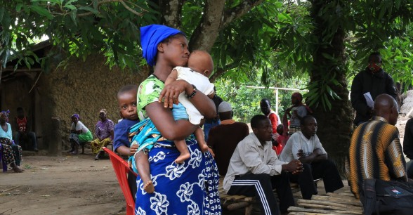 Kumba Kamara, mother of two, attends a Covid-19 sensitaization meeting under mango trees at Bassia Village organised by Concern. Photo: Mohamed Saidu Bah
