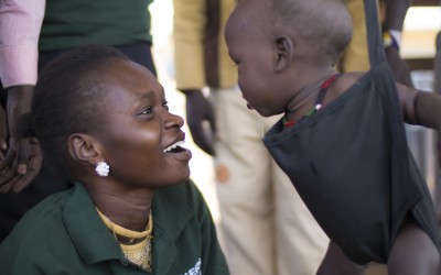 14 month old Anger Adim Garang, a boy, is one of twins admitted to the outpatient therapeutic program (OTP) run by Concern in Maduany in Aweil North, South Sudan. Pictured here with Monica Mawien a supervisor with the Concern community nutrition team. Photo: Kieran McConville/ Concern Worldwide