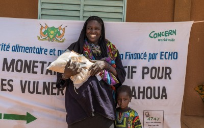 Ebatou Malik receives a distribution of cash and fortified flour from Concern to help meet her basic needs during the hunger gap. The fortified flour is for her daughter Hamidou (2) and it contains vital nutrients and vitamins to help keep her well-nourished. Photo: Apsatou Bagaya / Concern Worldwide.