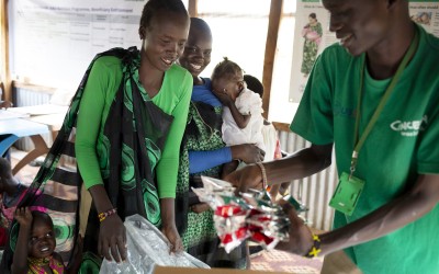Yien Gatbel, Concern Worldwide staff gives out Plumpy nut and fortified cereals to the parents of malnourished babies and children at the Concern Worldwide nutrition clinic in PoC 3 in Juba South Sudan. Photo: Abbie Trayler-Smith / Concern Worldwide