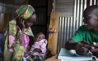 William Diang, Asisstant Programme Officer checks over Myaboth* and baby Makur* at the Concern Worldwide nutrition clinics in a PoC in Juba South Sudan. Photo: Abbie Trayler-Smith