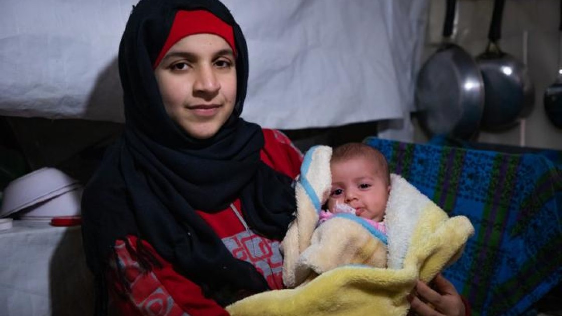 Wafdeh* (20) with her youngest daughter Rajaa* in their makeshift kitchen. Photo: Gavin Douglas