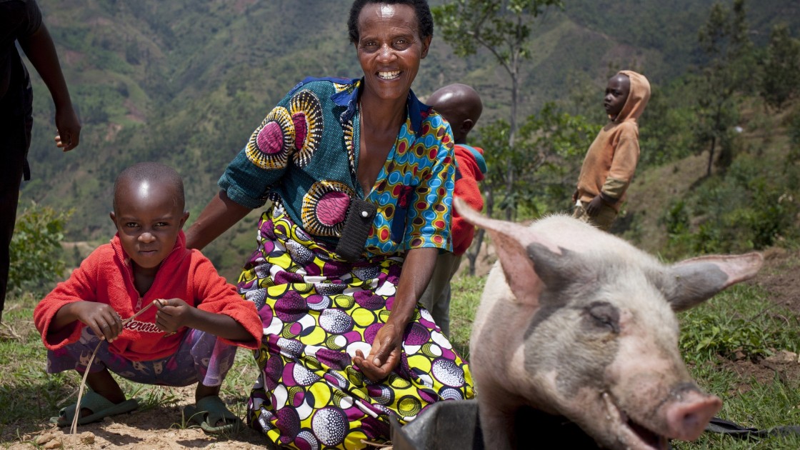 Violette and her son Lievain with the pig she has bought from the profits of her business at her home in Burundi. Photo: Abbie Trayler-Smith
