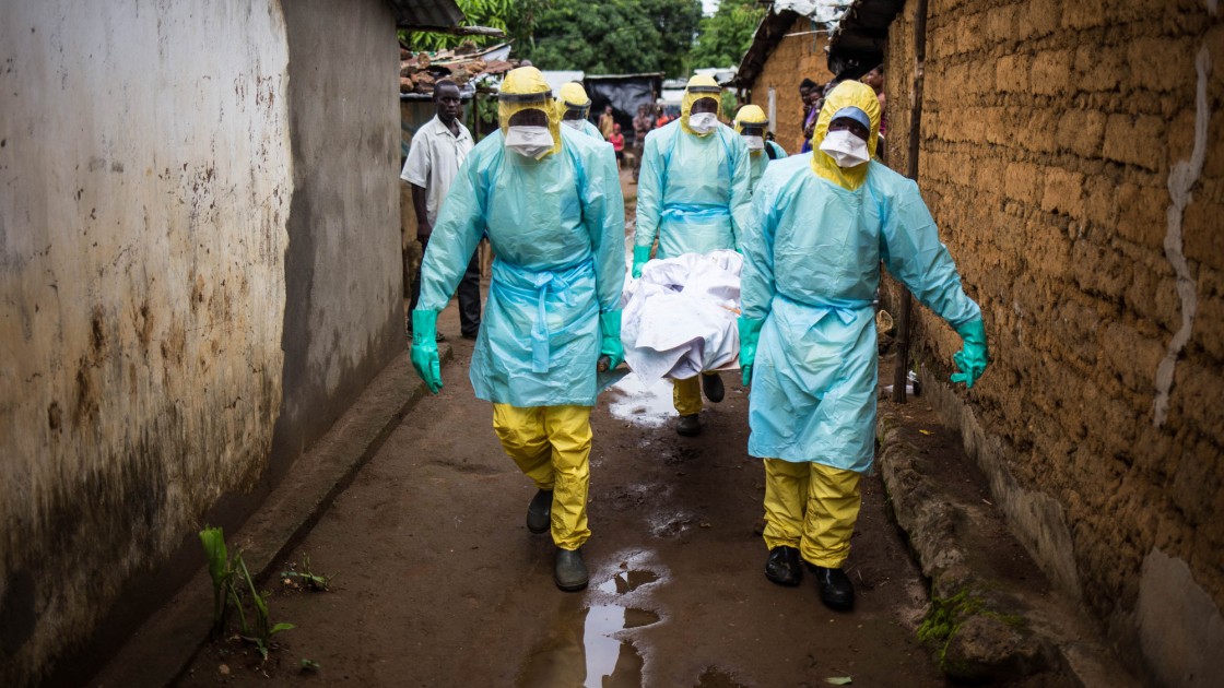 A burial team collects a corpse from inside a house in the east of Freetown, Sierra Leone.