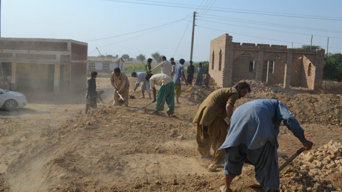 People in Pakistan building an embankment to protect their community from flooding. Credit: Qurban Ali/Bright Star Development Society