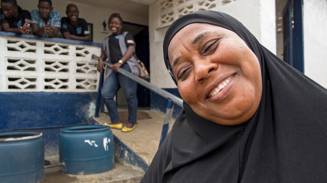 Kadiatu S Kouyateh with water and sanitation committee members outside a community latrine and shower facility that they oversee in Montserrado County, Liberia. For years this area has struggled with poor drainage and a lack of sanitation facilities. Phot