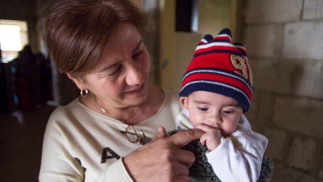 Maria Nader, Community Site Coordinator for Concern Worldwide with a baby born in Lebanon to Syrian parents in Hazzoury collective centre, run by Concern Worldwide in Halba, Lebanon. Photo: Kieran McConville/Concern Worldwide.