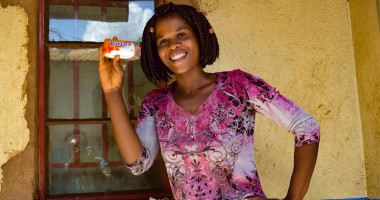 Smiling young woman Alice Eneya holds up soap she received from Concern.