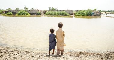 Children look across the floodwaters in Sindh province, Pakistan, where millions of people need urgent help. DEC charity Islamic Relief is providing emergency food and temporary shelter as families do all they can to keep safe and survive. Photo: Islamic Relief