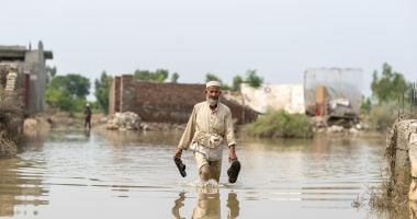 Man walking through floodwater in Pakistan