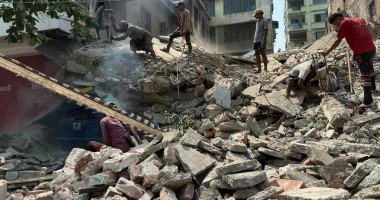 People stand on top of rubbble from the Myanmar earthquake