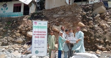 Family receiving dry food ration packs in Pakistan