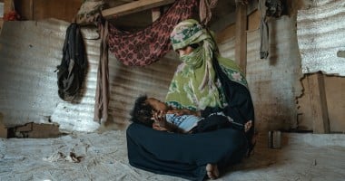 A mother cradles her young son in a displacement camp in Yemen