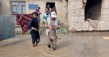 A Concern staff member walks through flood waters in Afghanistan