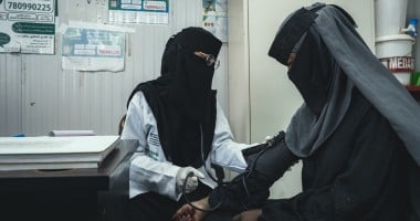 Woman providing health check up to a patient