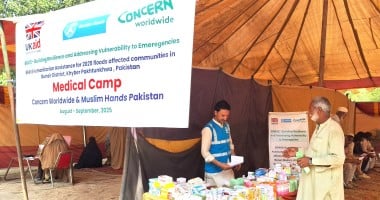 An aid worker provide essential supplies to a man in Pakistan
