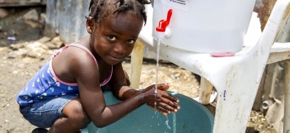 Cherica washes her hands in Cite Soleil slum, a district of Port-au-Prince, Haiti.