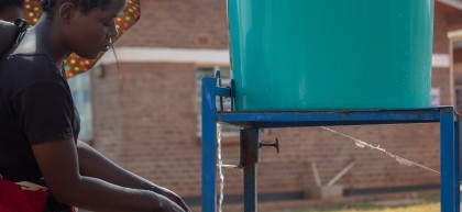 Jessy, washing hands at the hospital's entrance before seeing her patient. Photo: Henry Mhango