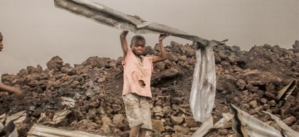 Amani, 12 years old, a child from the Buhene district in the north of Goma, collects the rubble after the volcanic eruption. Photo: Esdras Tsongo/Concern Worldwide