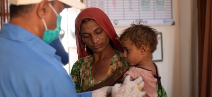 Nutrition Assistant, Santosh Kumar, checks a child for malnutrition at a Concern health centre in Umerkot, Sindh. Photo: Khaula Jamil / Concern Worldwide