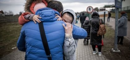 A man hugs his daughter and grandaughter after they crossed the border from Ukraine to Poland. Numerous Ukrainians are leaving the country fleeing the conflict.
