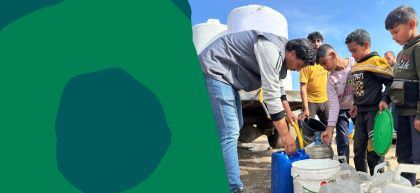Children and a man gather around water containers  in Gaza as clean water is distributed from a yellow hose into jerrycans and buckets, with large white water tanks on a truck in the background.